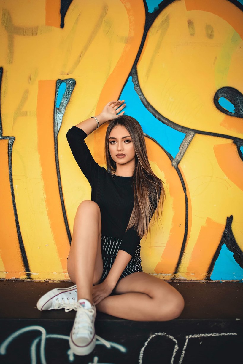 Woman Sitting up Against Graffiti Wall